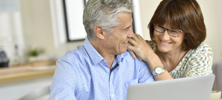 Una pareja leyendo el boletín electrónico de CenterWell Pharmacy sobre el programa de ayuda adicional de Medicare.​​ 